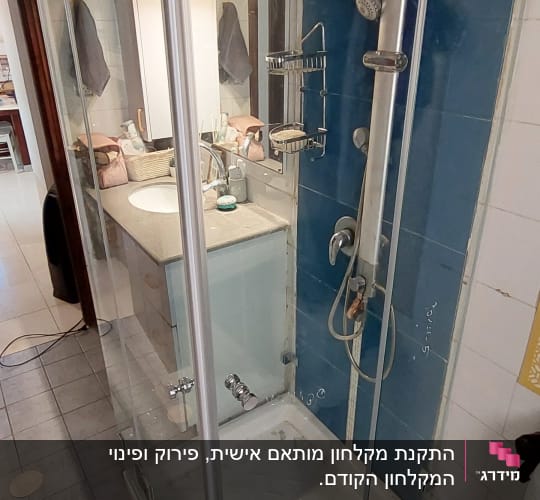 מקלחון זכוכית עם ראש מקלחת וכיור בחדר אמבטיה